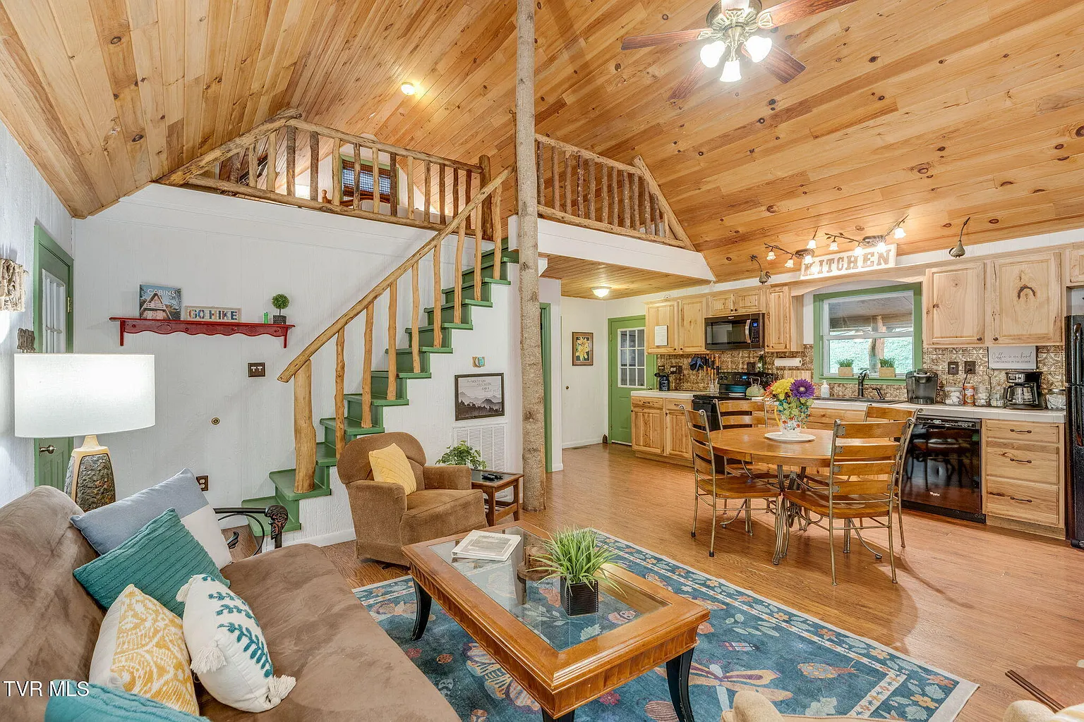 Bear cabin living area with loft staircase and open kitchen