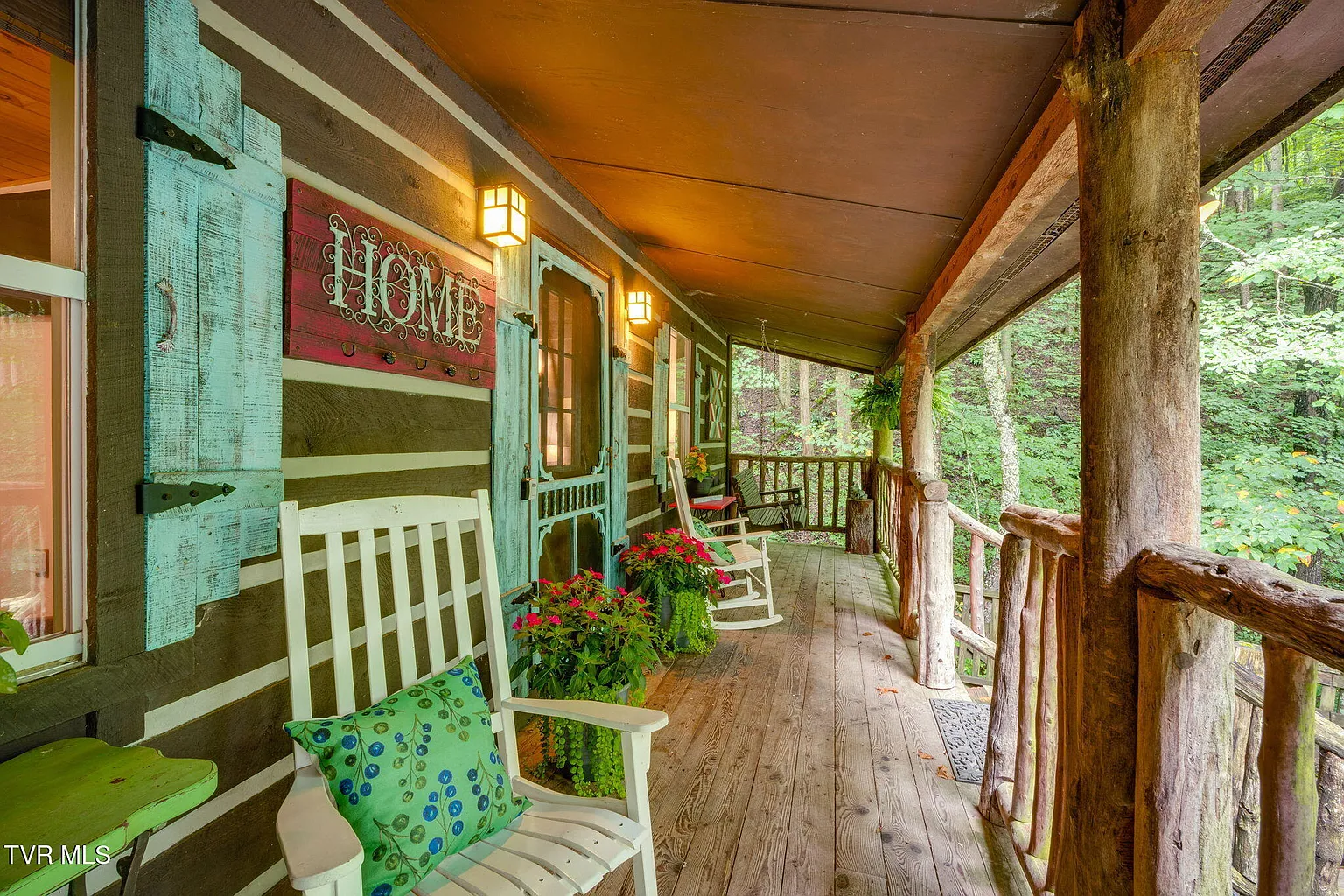 Bear cabin porch with white rocking chairs and turquoise shutters